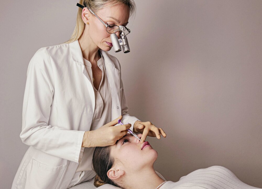 Dr. Dominique Oppowa mit Lupenbrille bei einer Lippenbehandlung